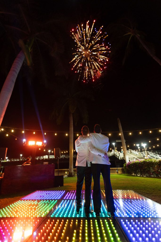 Couple watching fireworks from the illuminated dance floor at Oscar's wedding venue in Puerto Vallarta