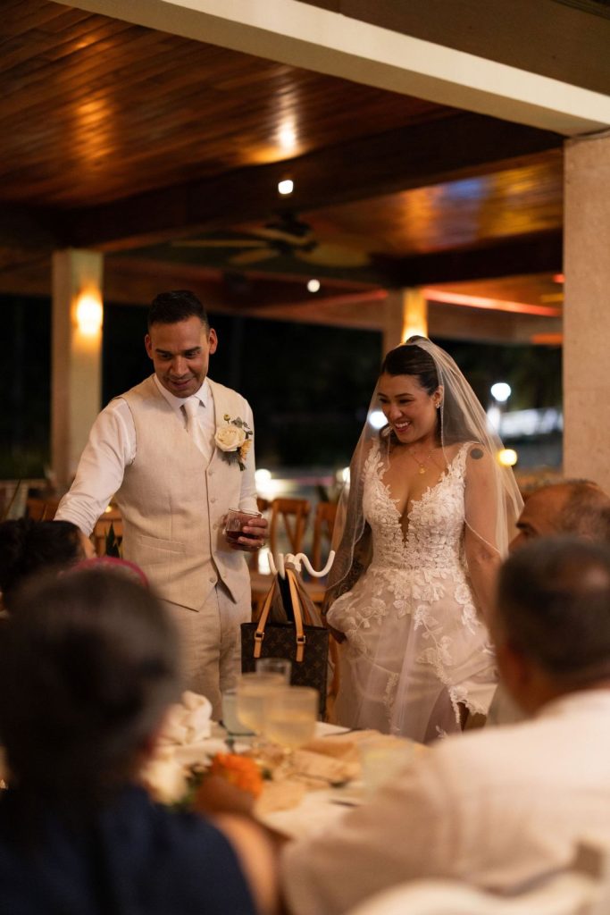 Newlyweds arriving at their wedding dinner under the palapa lights at Oscar's