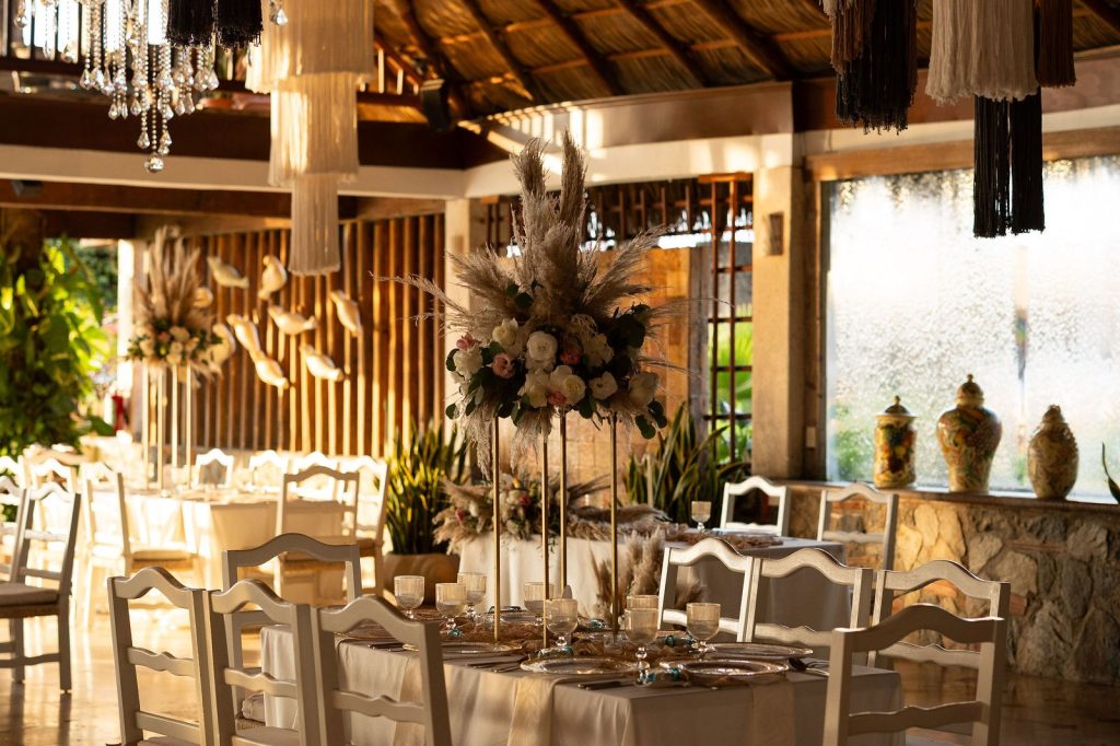 Event salon with chandelier and floral centerpieces set for a wedding at Oscar’s in Puerto Vallarta